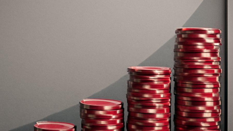 Doubling ladder of casino chips rising toward a table limit wall