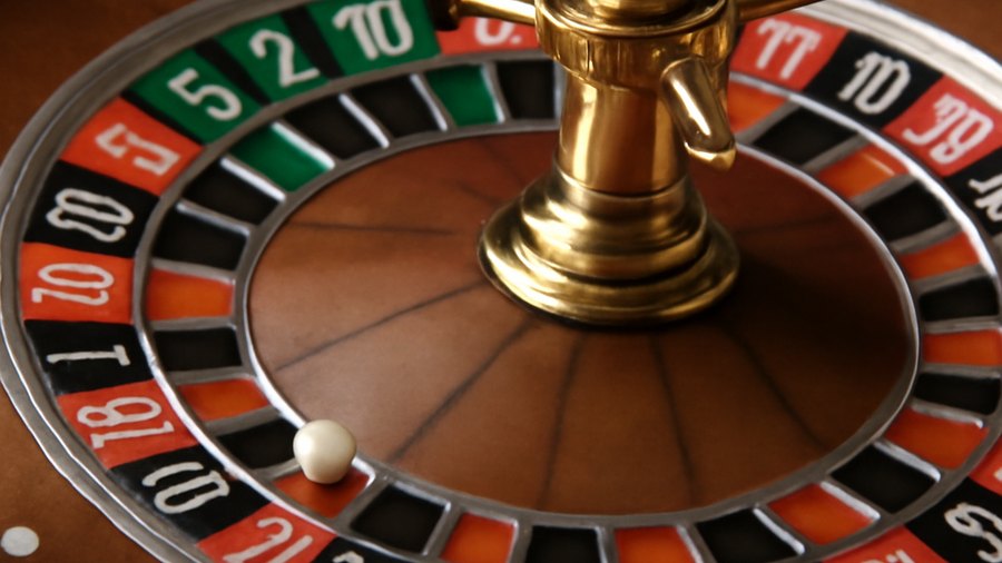 Roulette wheel emphasizing red black and green zero pockets as the source of house edge